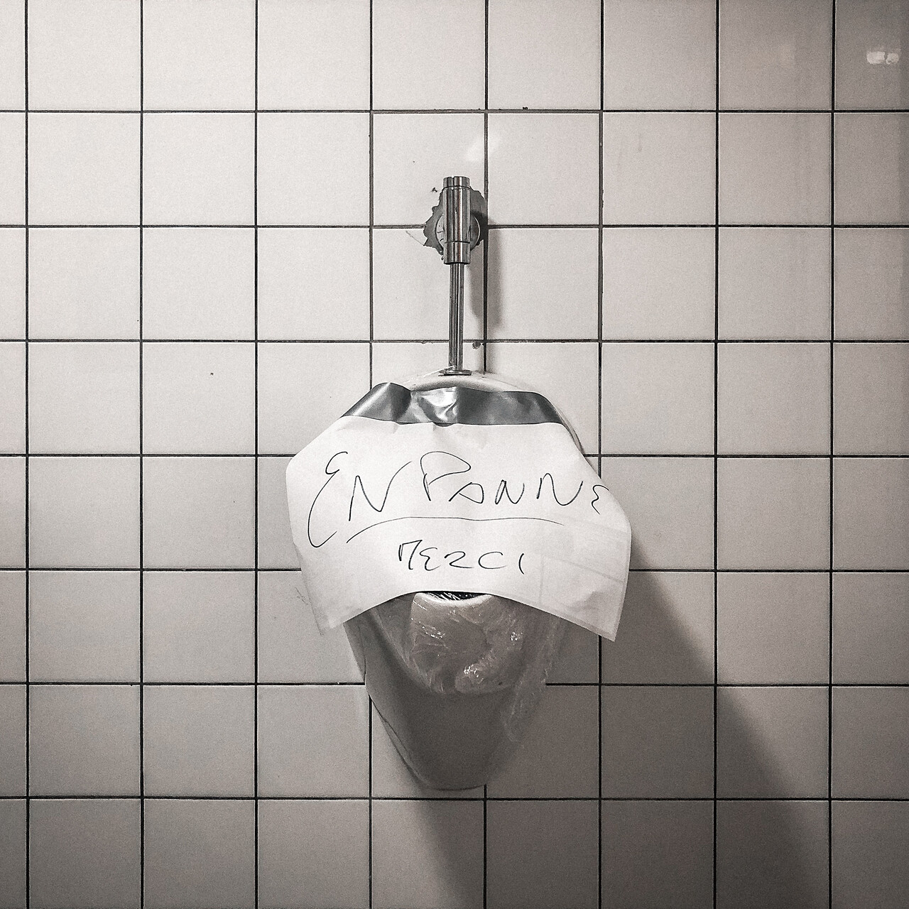 Un urinoirs couvert d'une affiche 'en panne'