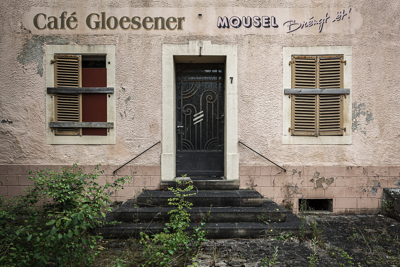 Façade délabrée, porte et volets à lamelles d'un café...