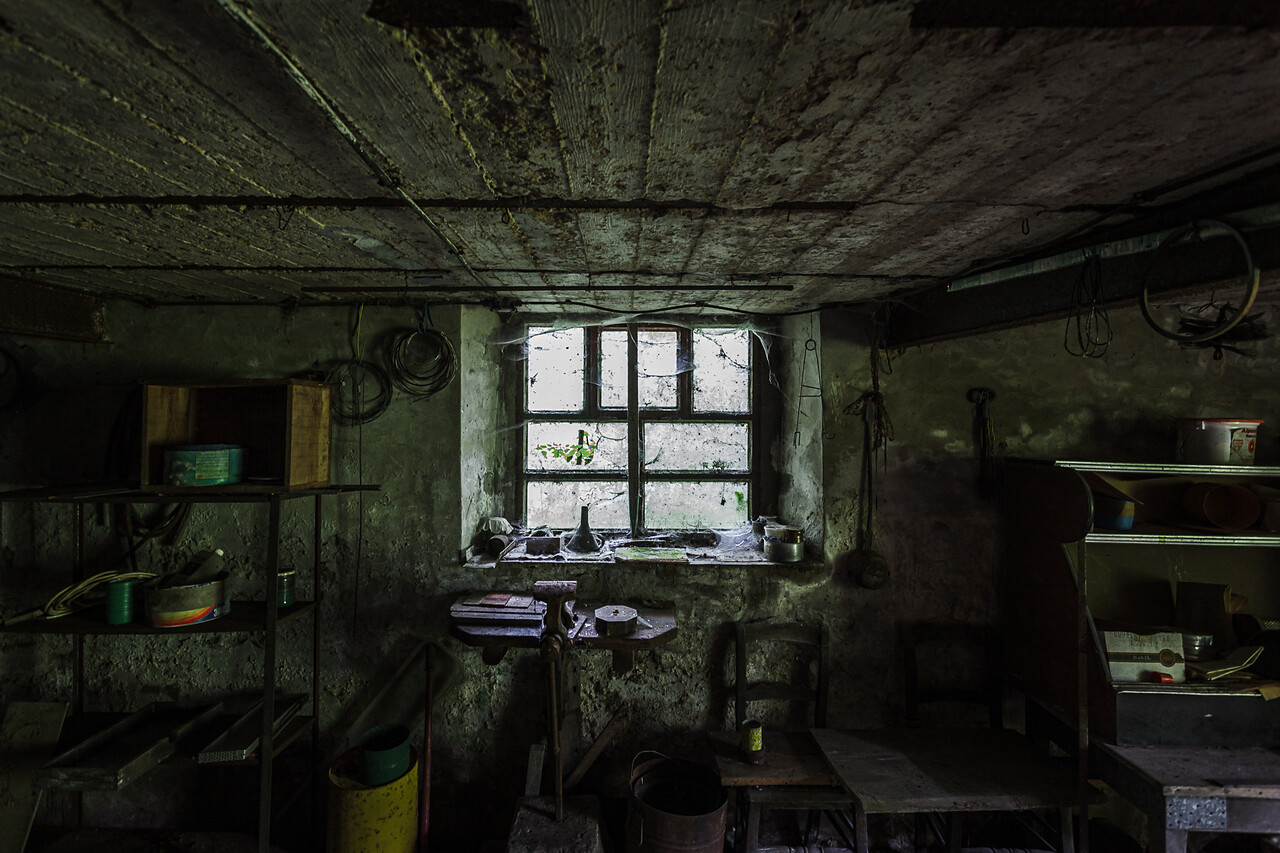 Fenêtre à croisillons couverte de toiles d'arignées dans un atelier délabré...