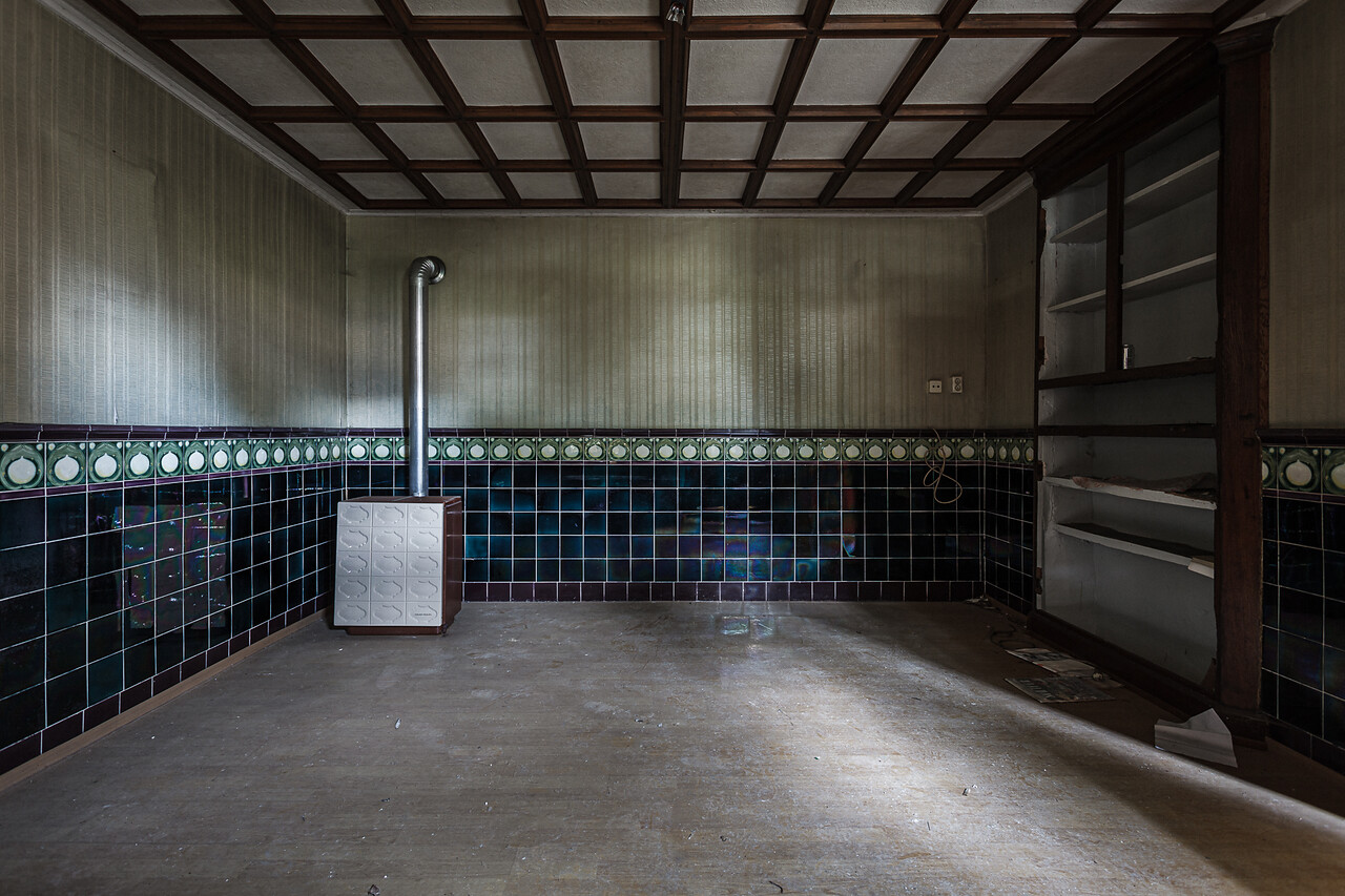 Plan large sur une pièce avec parquet et carreaux mureaux et un poele de chauffage....