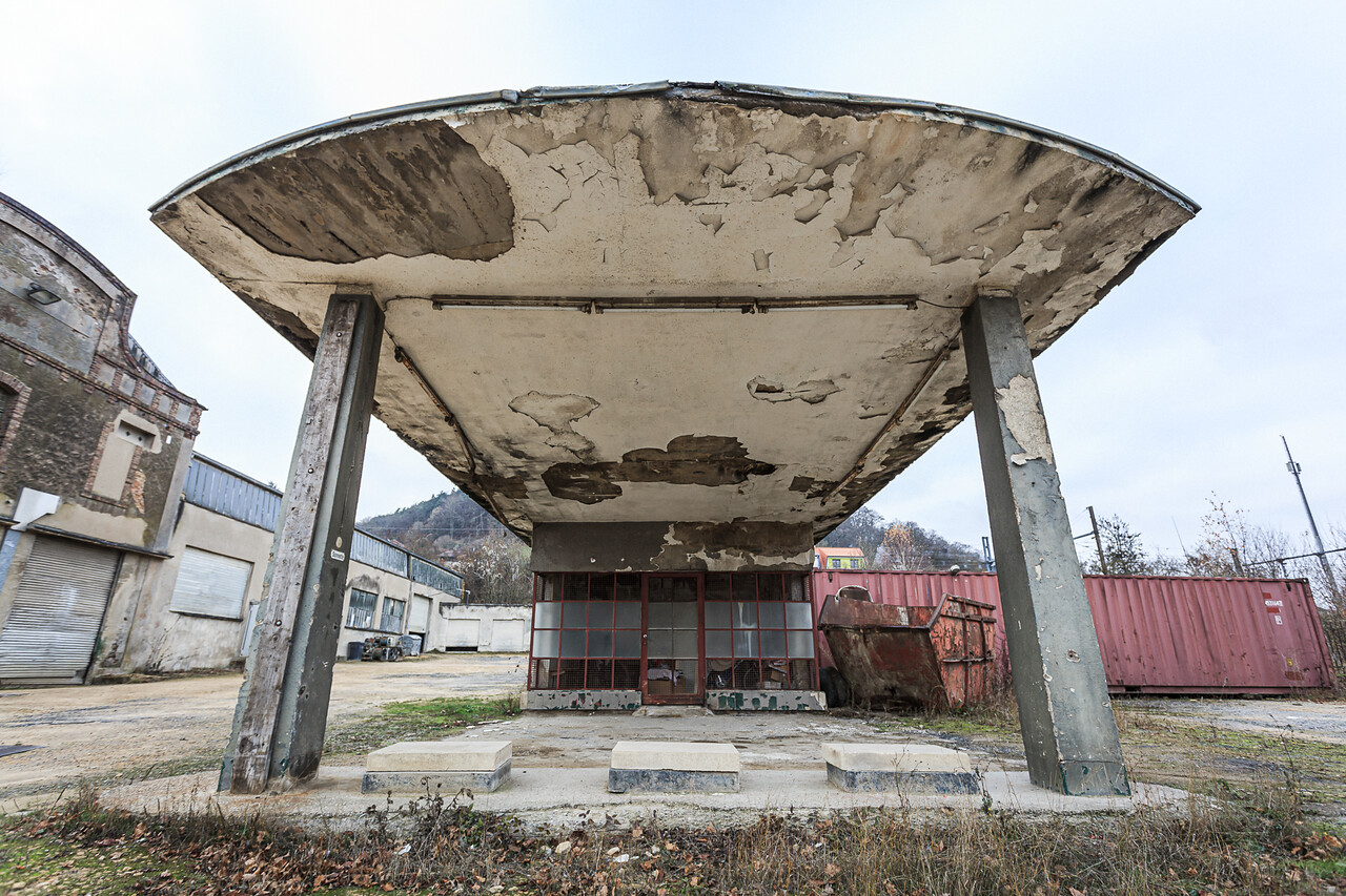 Plan large sur une ancienne station service à l’abandon.