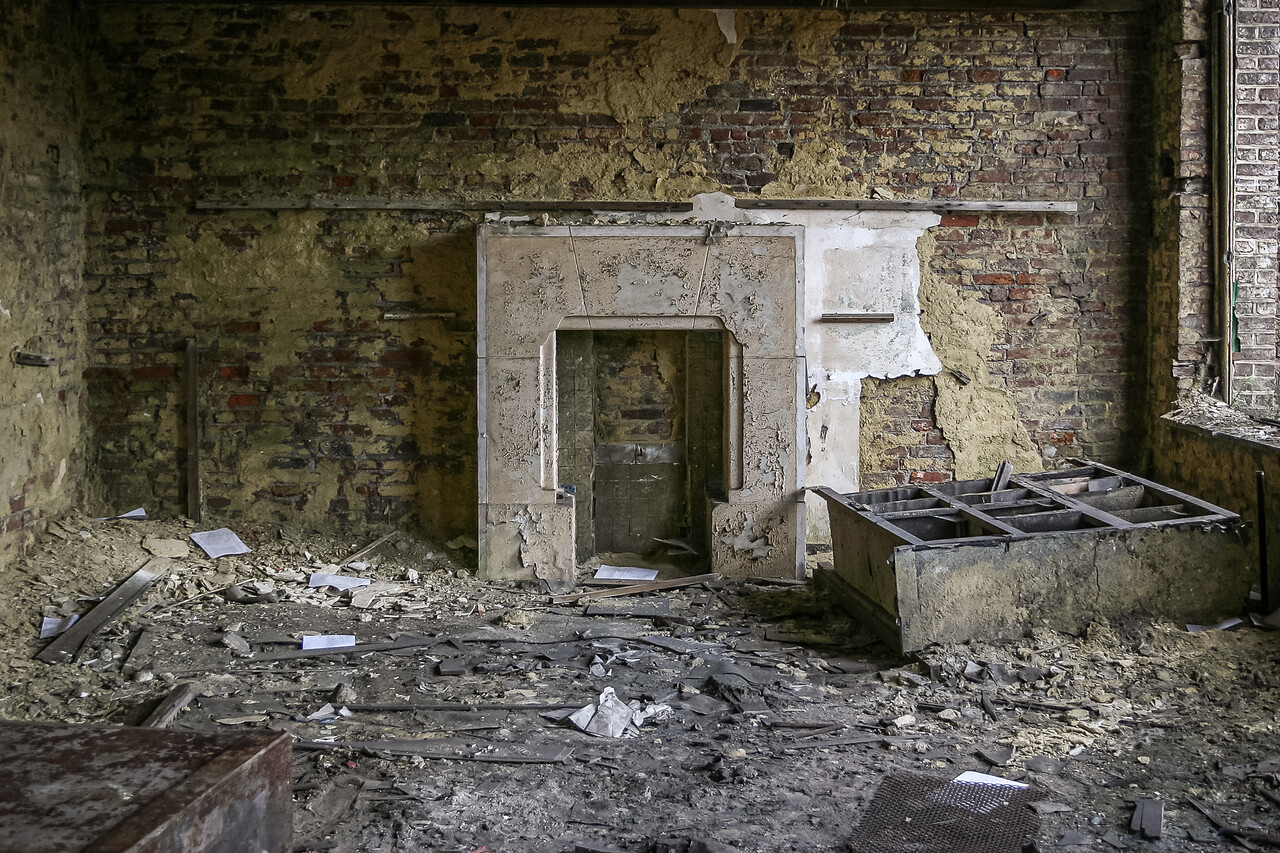 Une cheminée dans une pièce délabrée et encombrée.