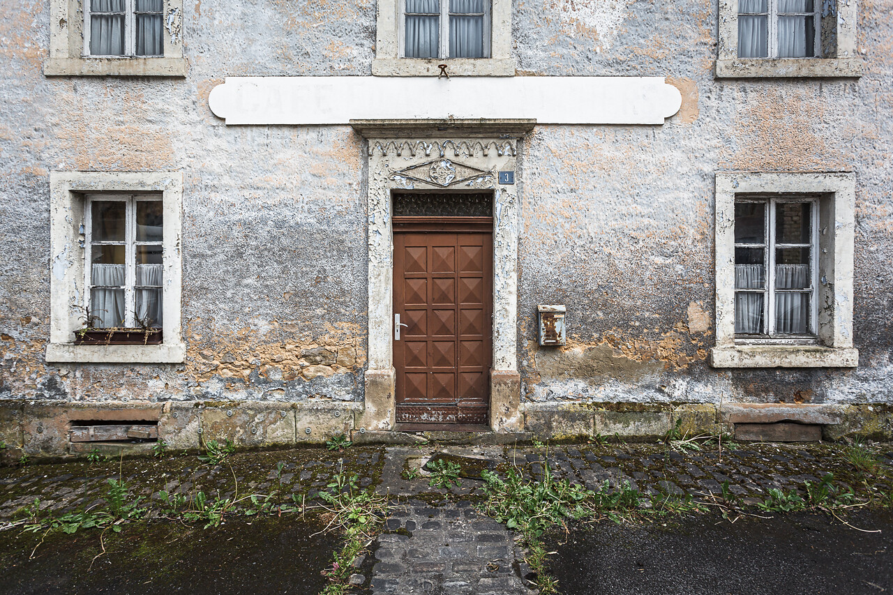 Façade décrépie d'un café abandonné.