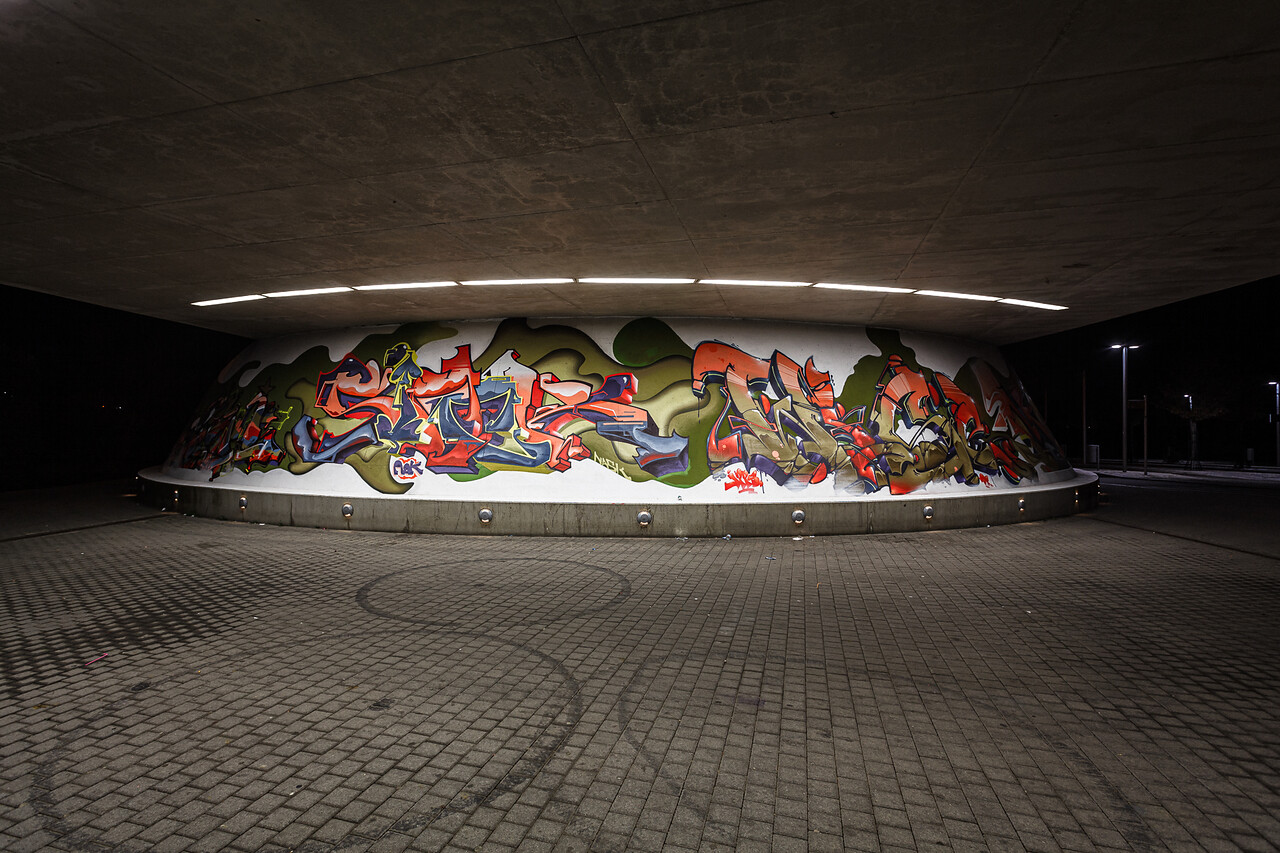 Grand angle sur les graffiti recouvrant le pied d'un pont à Lamadelaine...