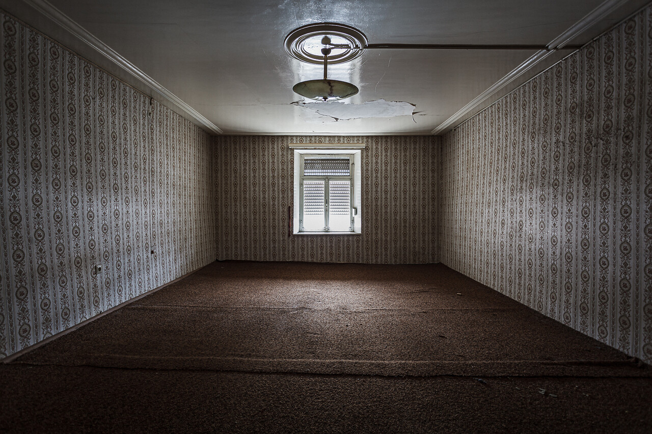 Perpective sur une chambre aux murs de travers décorés de papier peint à motifs...