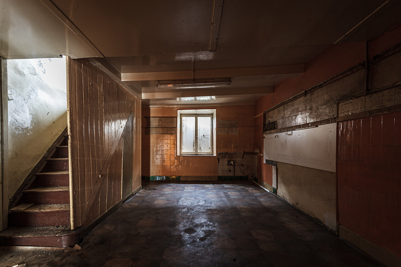 Perspective sur une vieille cuisine vide dont les murs et le plafond sont de travers...