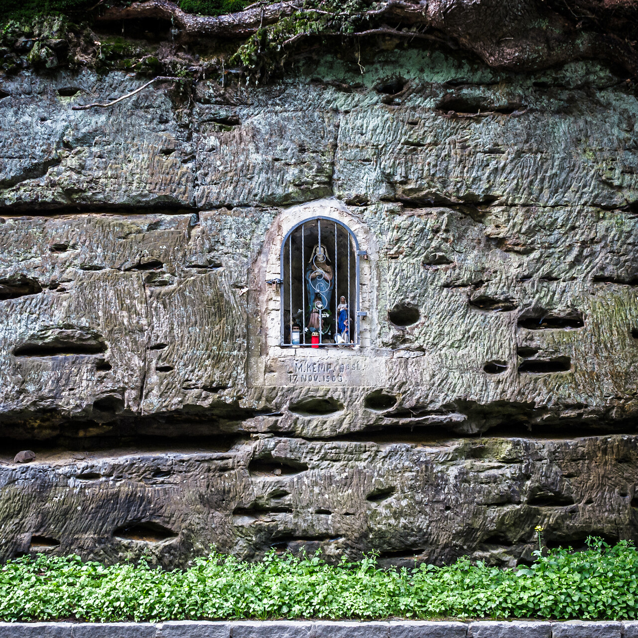 Statue de la vierge dans une alcôve creusée à même la roche.