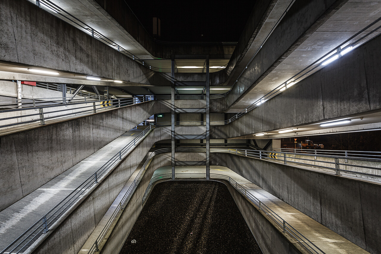 Perpective sur les rampes de parking éclairée la nuit.