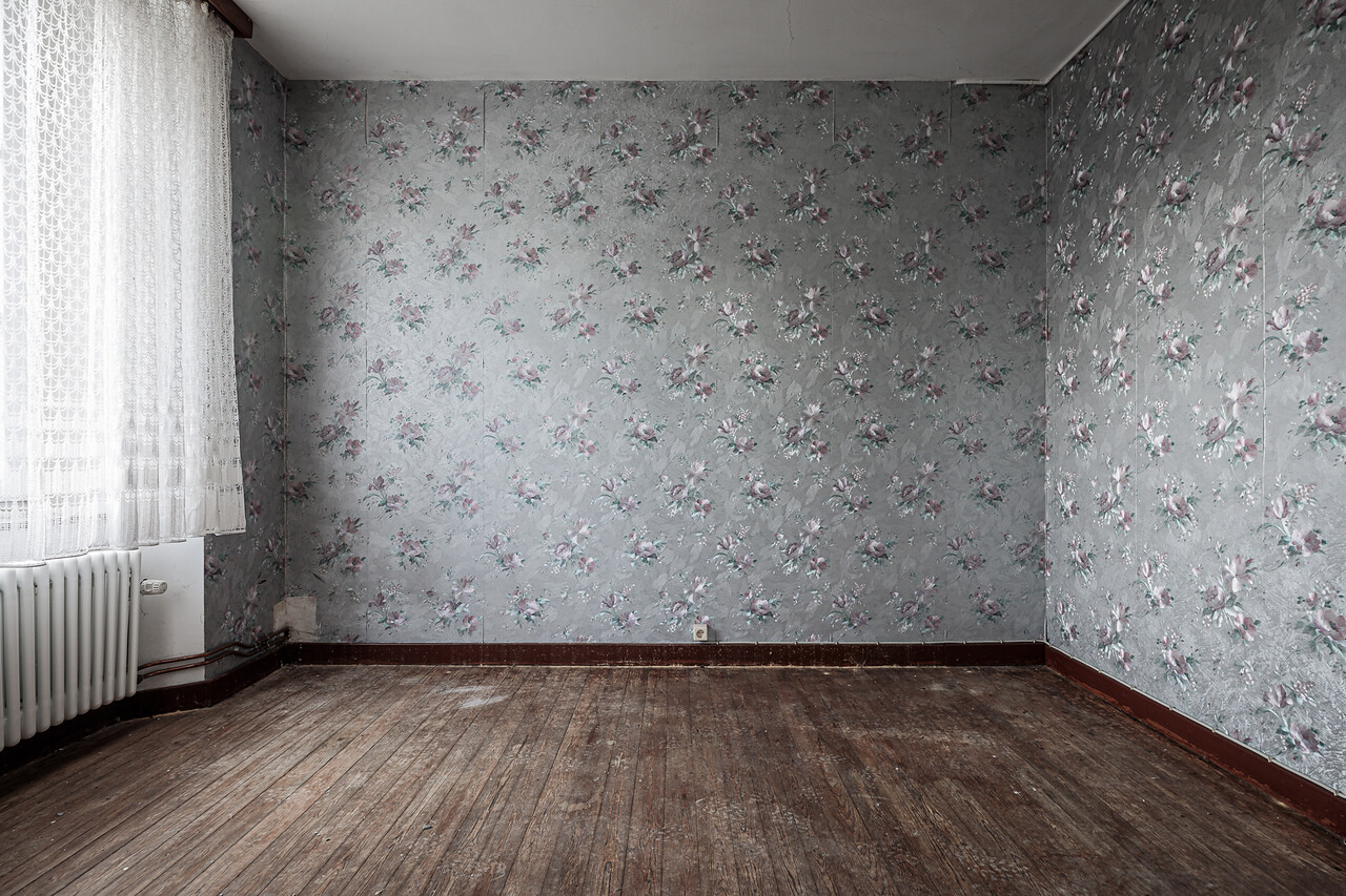 Chambre vide et son plancher massif décorée de papier-peint argenté à motifs floraux ...