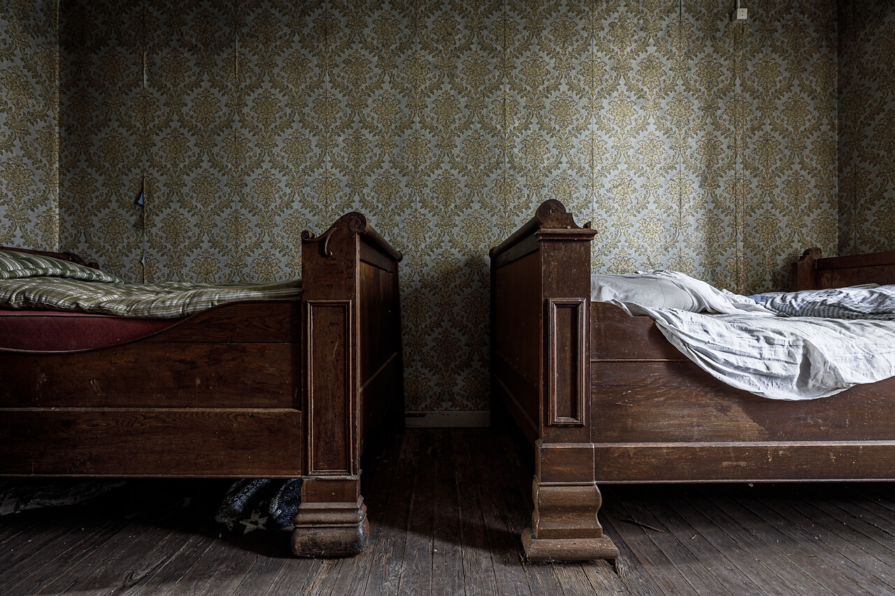 Chambre au papier-peint à motifs floraux et ses deux lits d'enfant en bois massif ...