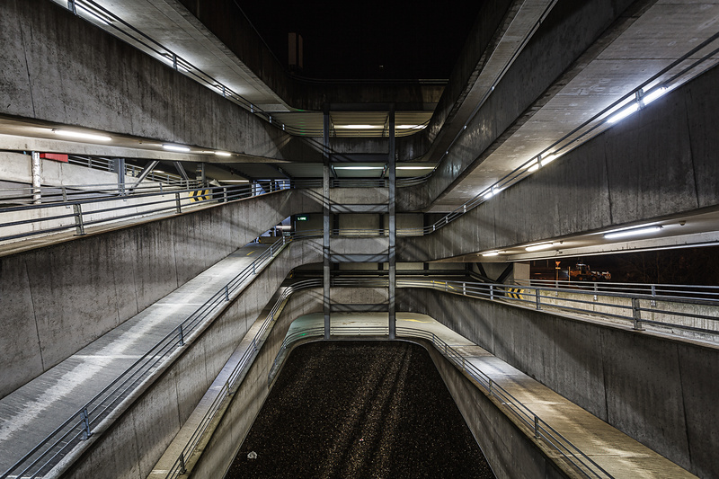 Perpective sur les rampes de parking éclairée la nuit.