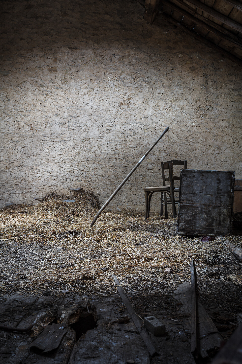 Une fourche plantée dans la paille d'un vieux fenil...