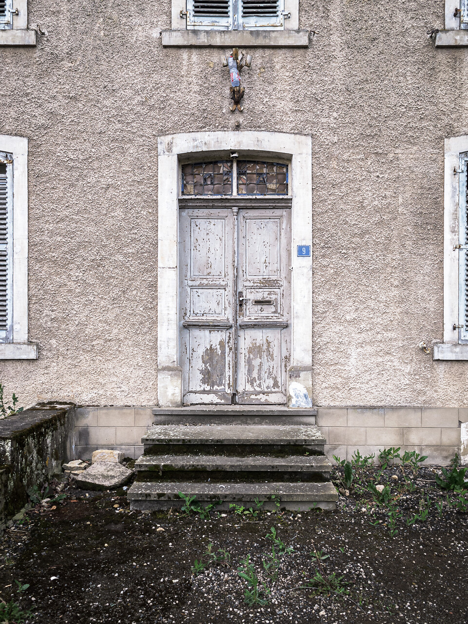 Porte d’une ancienne école primaire à l’abandon.