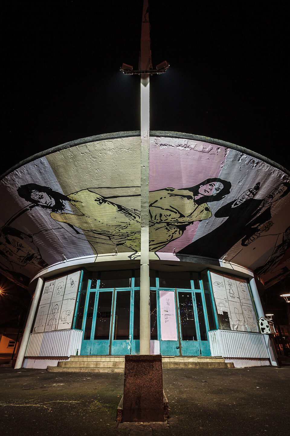 Plan large de nuit sur un kiosk d’information à l’abandon.