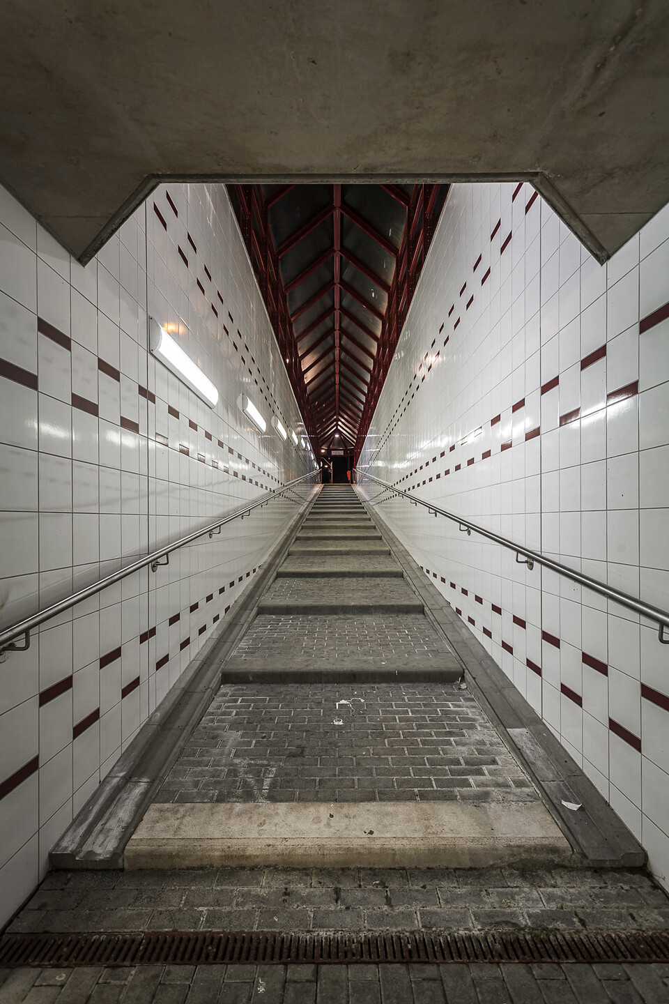 Perspective de nuit sur une rampe menant à un quai de gare.