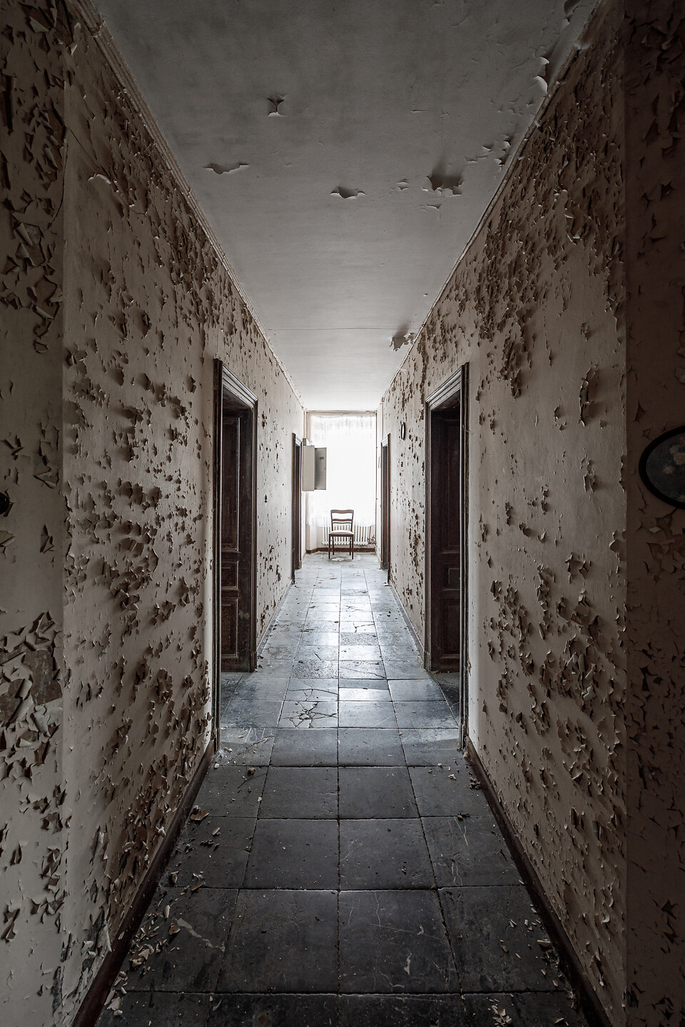 Couloir du rez-de-chaussée avec son sol en pierres bleues et aux murs à la peinture écaillée ...