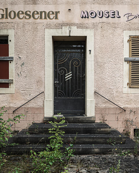 Façade délabrée, porte et volets à lamelles d'un café...