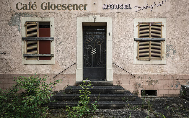 Façade délabrée, porte et volets à lamelles d'un café