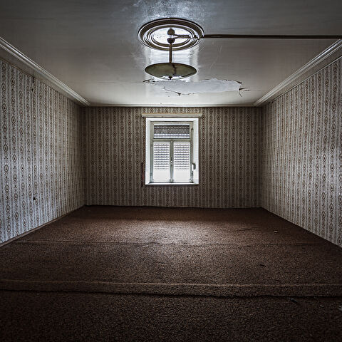 Perpective sur une chambre aux murs de travers décorés de papier peint à motifs...