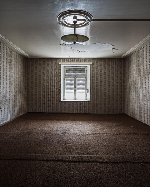 Perpective sur une chambre aux murs de travers décorés de papier peint à motifs...