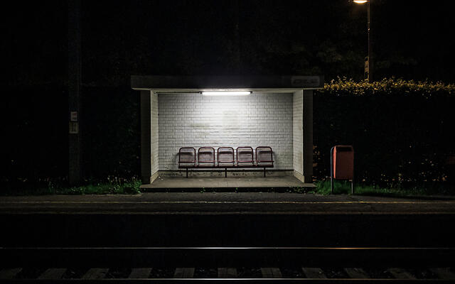 Abri pour voyageurs sur le quai d'une gare CFL la nuit.
