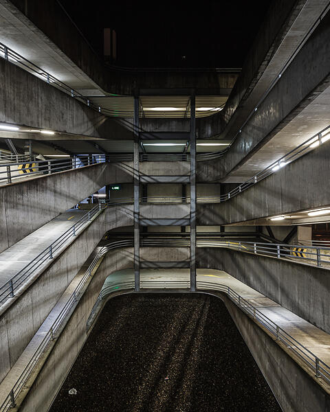 Perpective sur les rampes de parking éclairée la nuit.