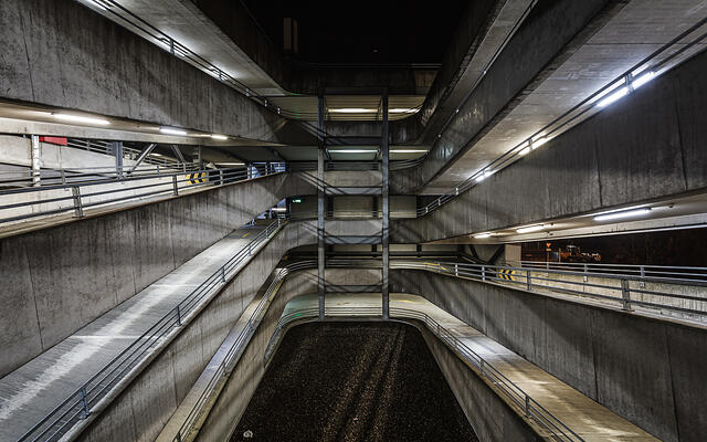 Perspective sur les rampes de parking éclairées la nuit.